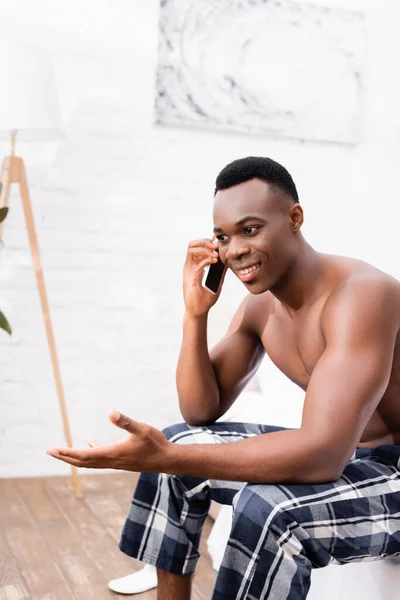 Afrikai Amerikai Férfi Kockás Nadrágban Beszél Okostelefonon Miközben Ágyon — Stock Fotó