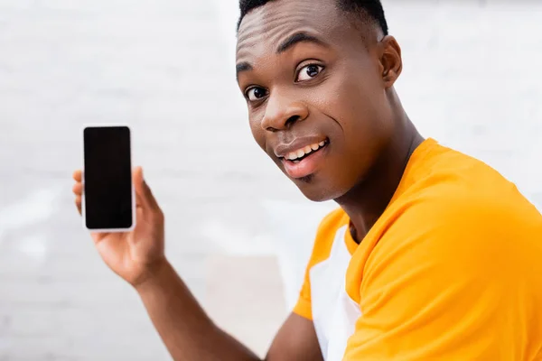 Sonriente Hombre Afroamericano Mirando Cámara Mientras Sostiene Teléfono Inteligente Con — Foto de Stock