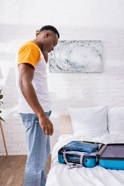 Side View Thoughtful African American Man Looking Suitcase Clothes Bed — Stock Photo, Image