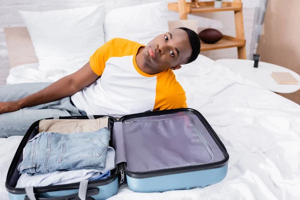 Suitcase Clothes African American Man Looking Camera Bed — Stock Photo, Image