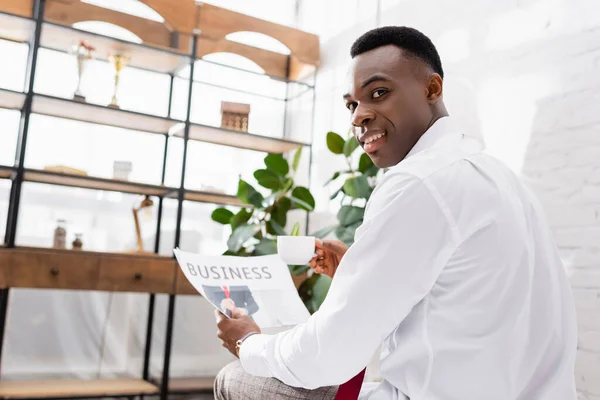 African American Businessman Smiling Camera While Holding Cup Newspaper Blurred — Stock Photo, Image