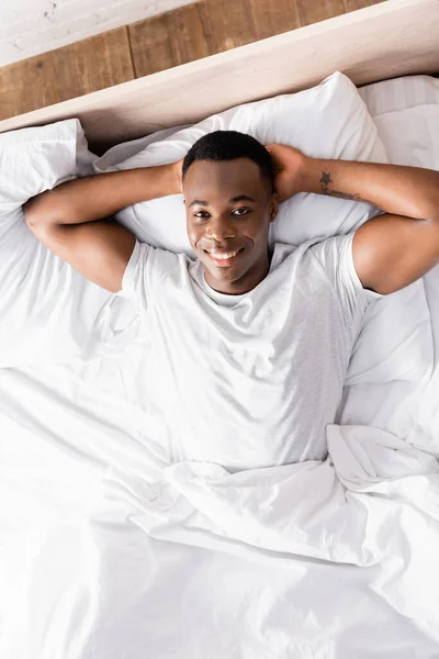 Top View Tattooed African American Man Smiling Camera Bed — Stock Photo, Image