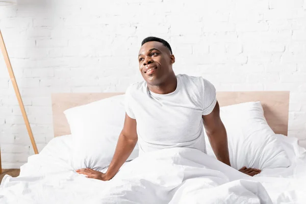Χαμογελώντας Αφροαμερικάνος Που Κάθεται Στο Κρεβάτι Πρωί — Φωτογραφία Αρχείου