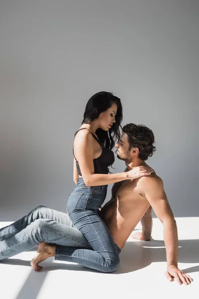 Sensual Mulher Abraçando Homem Sem Camisa Fundo Cinza Com Sombra — Fotografia de Stock