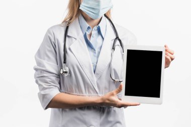 Tıbbi maskeli hemşire ve beyaz önlüklü beyaz önlüklü beyaz ekranlı, boş ekranlı dijital tablet. 