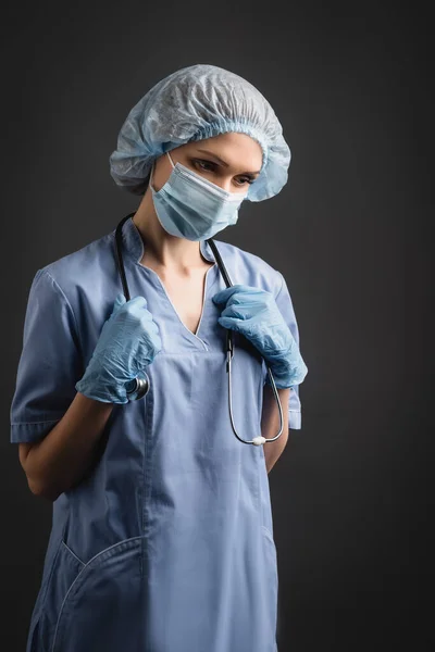 Nurse Medical Mask Latex Gloves Adjusting Stethoscope Isolated Dark Grey — Stock Photo, Image