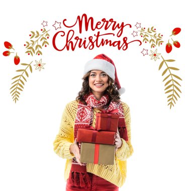 joyful young woman in santa hat and scarf holding gifts near merry christmas lettering and illustration on white clipart