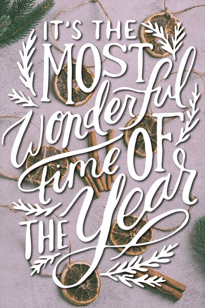 Вид сверху высохших апельсиновых кусочков с нитками, палочками камамона и сосновыми ветвями рядом с ним в самое чудесное время года. 