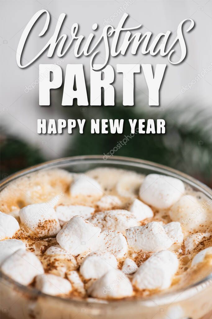 Close up view of glass cup of cocoa with marshmallows and cinnamon near christmas party, happy new year lettering 