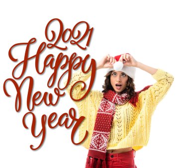 Noel Baba şapkasına dokunan eşarplı genç bir kadın 2021 'e yakın beyaz harflerle mutlu yıllar.