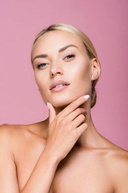 Güzel sarışın kadın, mükemmel tenli, yüzlerine dokunan pembe tenli.