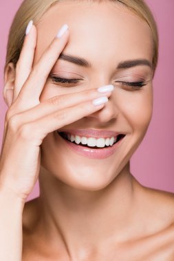 Gülümseyen güzel sarışın kadın, pembe bir yüzle poz veriyor.