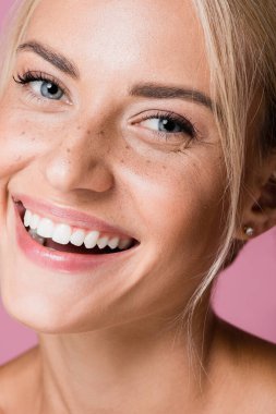 Gülümseyen, pembe çilli güzel sarışın kadın.