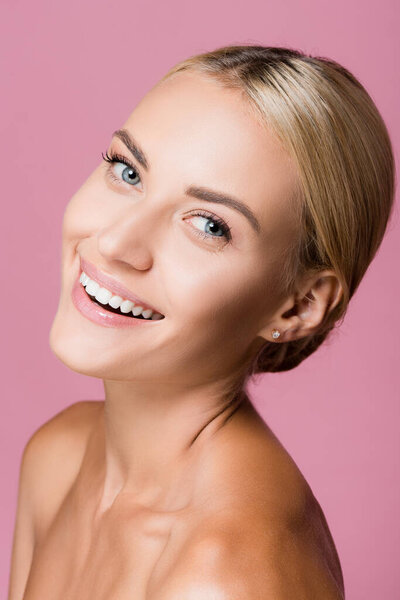 smiling beautiful blonde woman with perfect skin isolated on pink