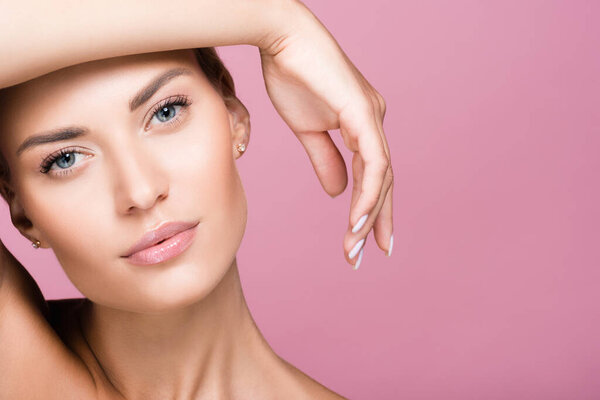 красивая блондинка позирует с рукой изолированы на розовый