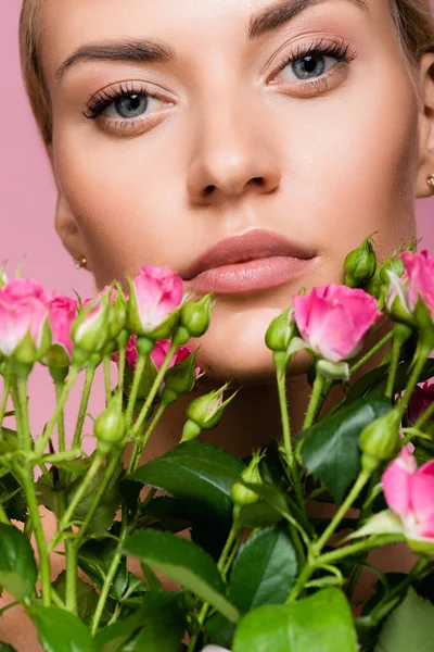 beautiful blonde woman with rose bouquet isolated on pink