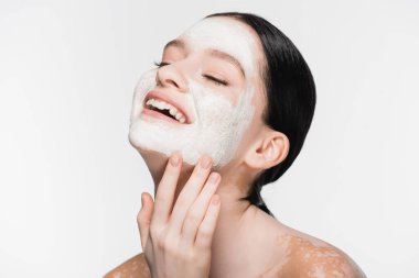 Yüzünde kil maske ve vitiligo olan gülümseyen genç ve güzel bir kadın.