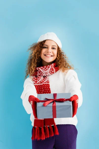 Cheerful Woman Hat Mittens Outstretched Hands Holding Wrapped Gift Box — Stock Photo, Image