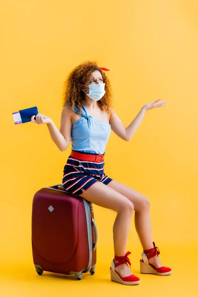 Confused Young Woman Medical Mask Holding Passport While Sitting Suitcase — Stock Photo, Image