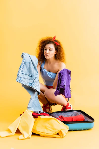 Confused Woman Sitting Suitcase Choosing Clothing Yellow — Stock Photo, Image