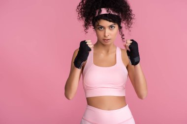 Spor giyim bölümündeki kıvırcık kadın. Pembe ellerle izole edilmiş kölelik.