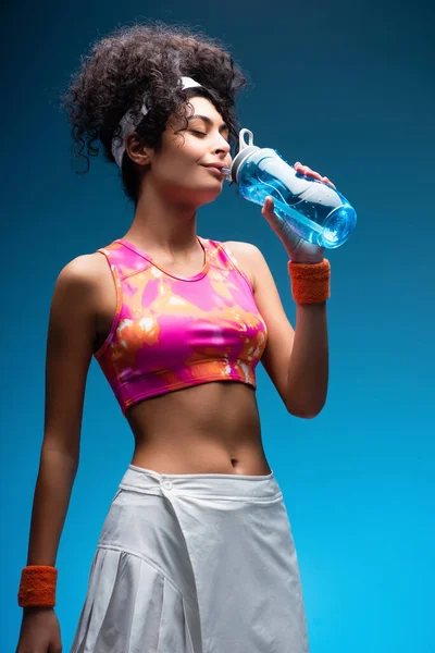 Kudrnatá Žena Sportovním Oblečení Pitná Voda Modré — Stock fotografie