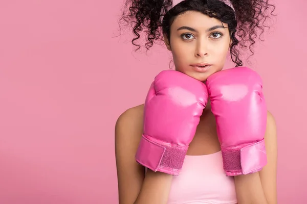 穿着运动服和拳击手套的年轻女运动员看着被粉色隔离的相机 — 图库照片