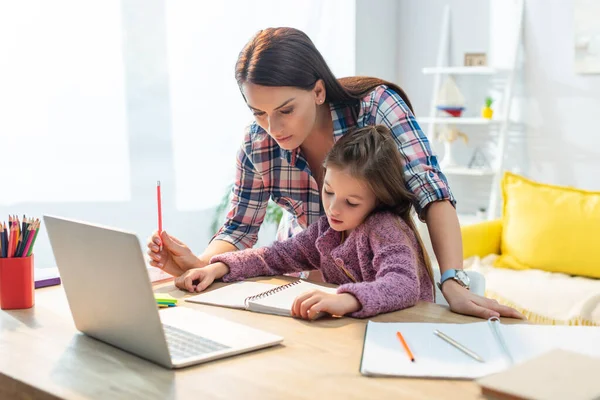 Madre Hija Mirando Cuaderno Cerca Computadora Portátil Escritorio Casa Sobre — Foto de Stock