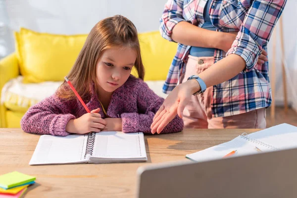 Hija Molesta Con Lápiz Cuaderno Cerca Madre Señalando Con Mano — Foto de Stock