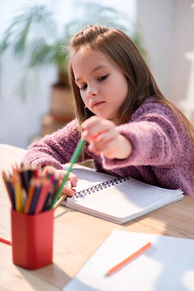 Mädchen Holt Buntstift Aus Halter Schreibtisch Mit Notizbuch Auf Verschwommenem — Stockfoto