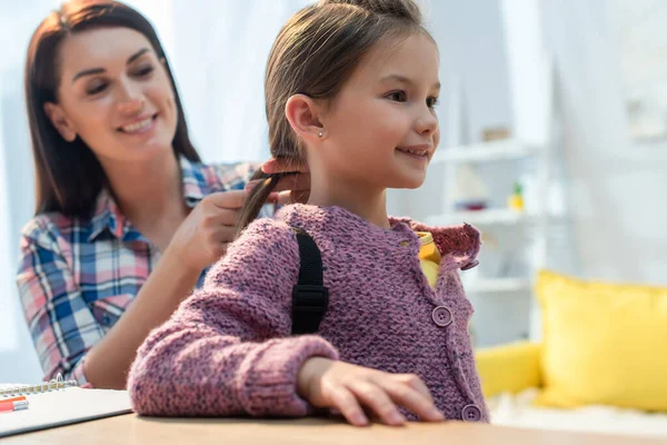 Feliz Madre Trenzando Pelo Hija Con Mochila Casa Sobre Fondo — Foto de Stock