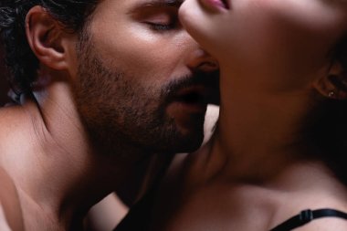 close up view of young man kissing neck of seductive woman clipart