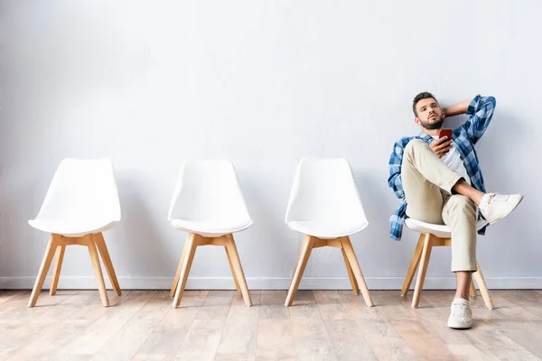 Young Man Cellphone Sitting Chair Hall — Stock Photo, Image