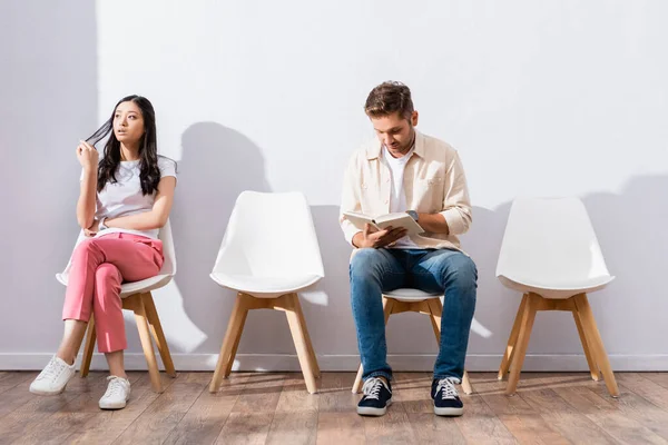 Aziatische Vrouw Zitten Buurt Man Lezen Boek Wachtrij — Stockfoto