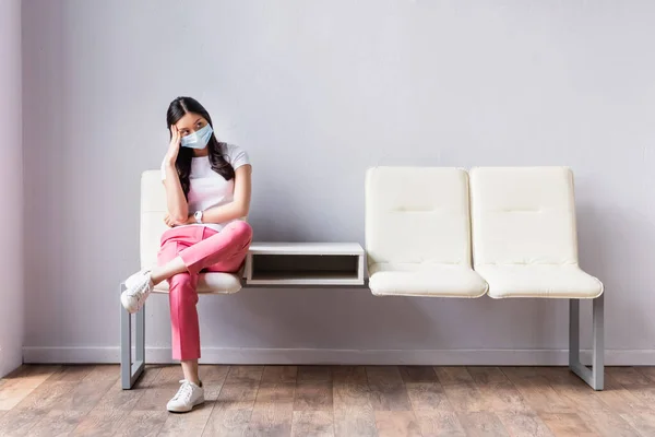 Tıbbi Maskeli Yorgun Asyalı Kadın Koridorda Sandalyede Bekliyor — Stok fotoğraf