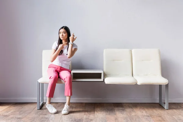 Mulher Asiática Apontando Com Dedo Para Relógio Pulso Cadeiras — Fotografia de Stock