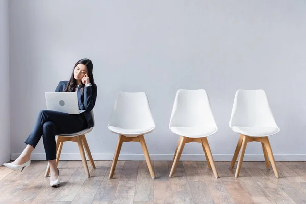 亚洲女商人在等待求职面试时在大厅里使用笔记本电脑 — 图库照片