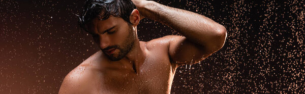 sexy shirtless man posing with closed eyes under rain on dark background, banner