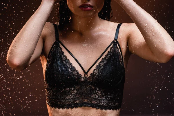 深色背景雨点下穿着黑色花边胸罩的女人的局部视图 — 图库照片