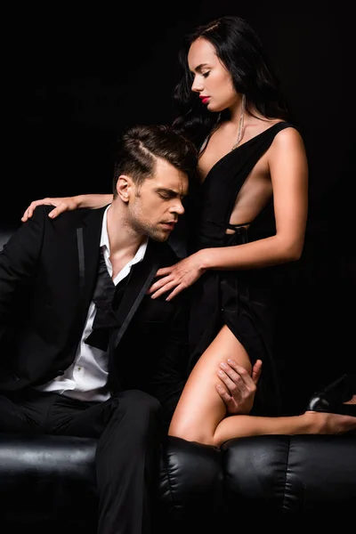 目を閉じて黒い服を着た魅惑的な女性の足に触れる男 — ストック写真