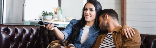 Jovem Dormindo Perto Mulher Sorridente Assistindo Segurando Controlador Remoto Banner — Fotografia de Stock