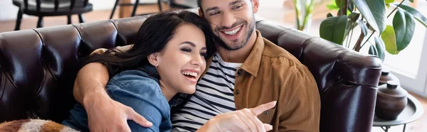Γελώντας Γυναίκα Δείχνοντας Δάχτυλο Ενώ Βλέποντας Τηλεόραση Χαρούμενο Φίλο Πανό — Φωτογραφία Αρχείου