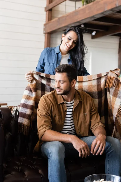 Mujer Feliz Cubriendo Novio Con Cálida Manta Cuadros Casa — Foto de Stock