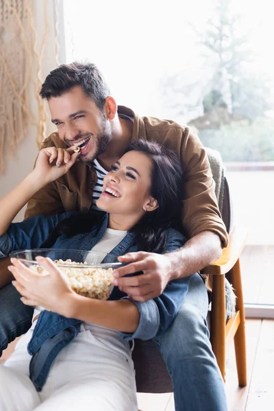 Vrolijke Vrouw Voeden Gelukkig Vriendje Met Popcorn Thuis — Stockfoto