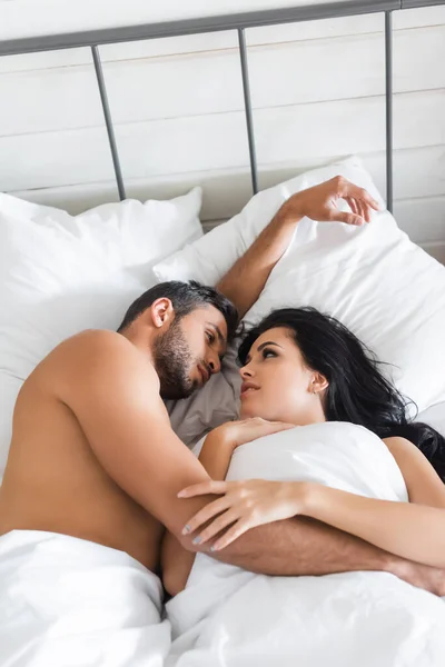 침대에 담요를 셔츠를 남녀가 서로를 쳐다보고 — 스톡 사진