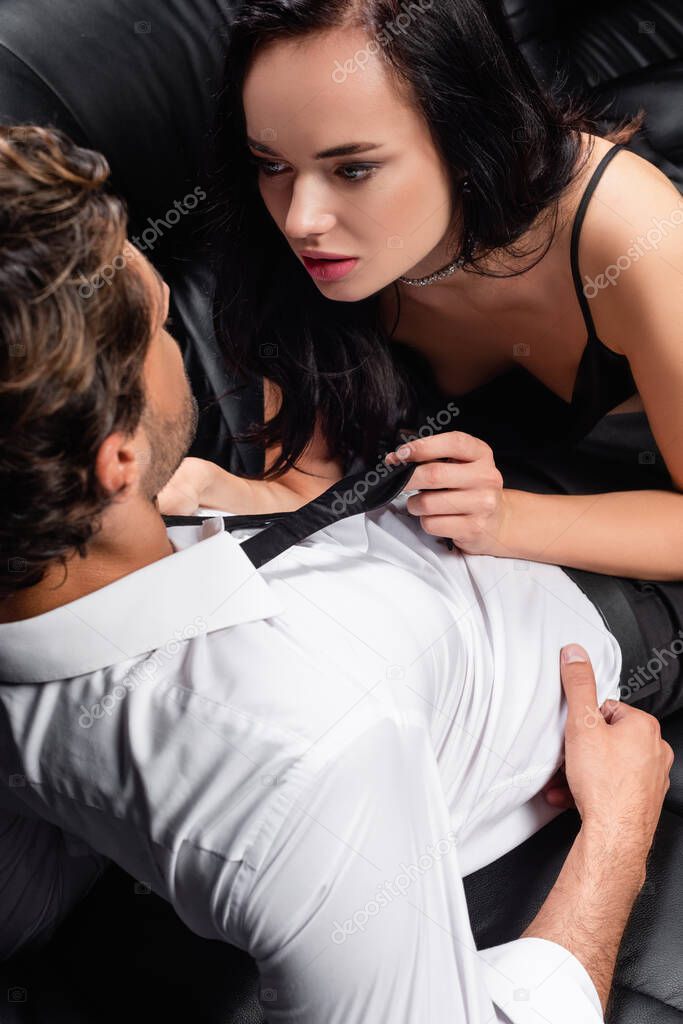 passionate brunette woman undressing man in white shirt