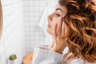 Banyoda eli yüzü birbirine yakın bir kadın var. 