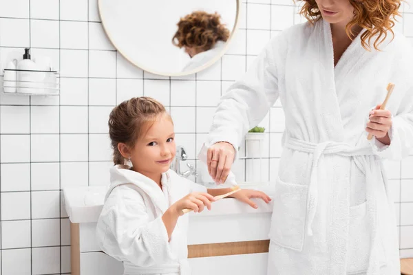 Madre Apretando Pasta Dientes Cepillo Dientes Cerca Hija Baño — Foto de Stock