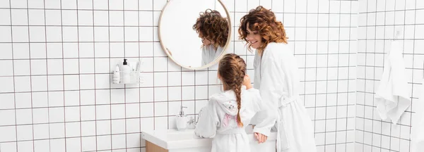 Donna Sorridente Accappatoio Guardando Figlia Vicino Lavandino Bagno Banner — Foto Stock