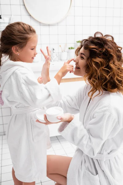 Ragazza Sorridente Che Applica Crema Cosmetica Sul Naso Madre Bagno — Foto Stock